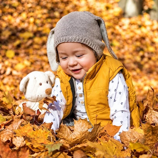 bebé a brincar no meio de folhas secas