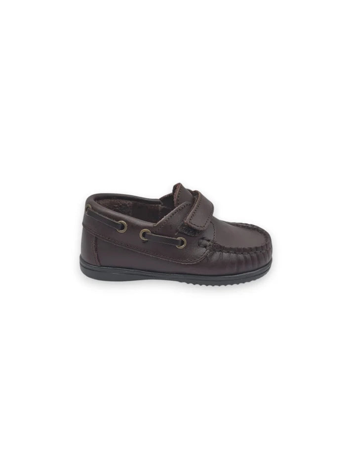 Perfil lateral de sapato de vela infantil em pele castanho escuro com fecho em velcro